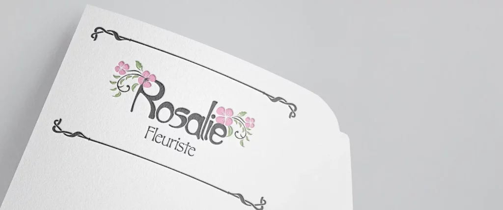 Gros plan du logo Rosalie fleuriste embossé sur un papier texturé épais. Rendu réaliste d'une identité visuelle fleuriste élégante et durable au toucher.